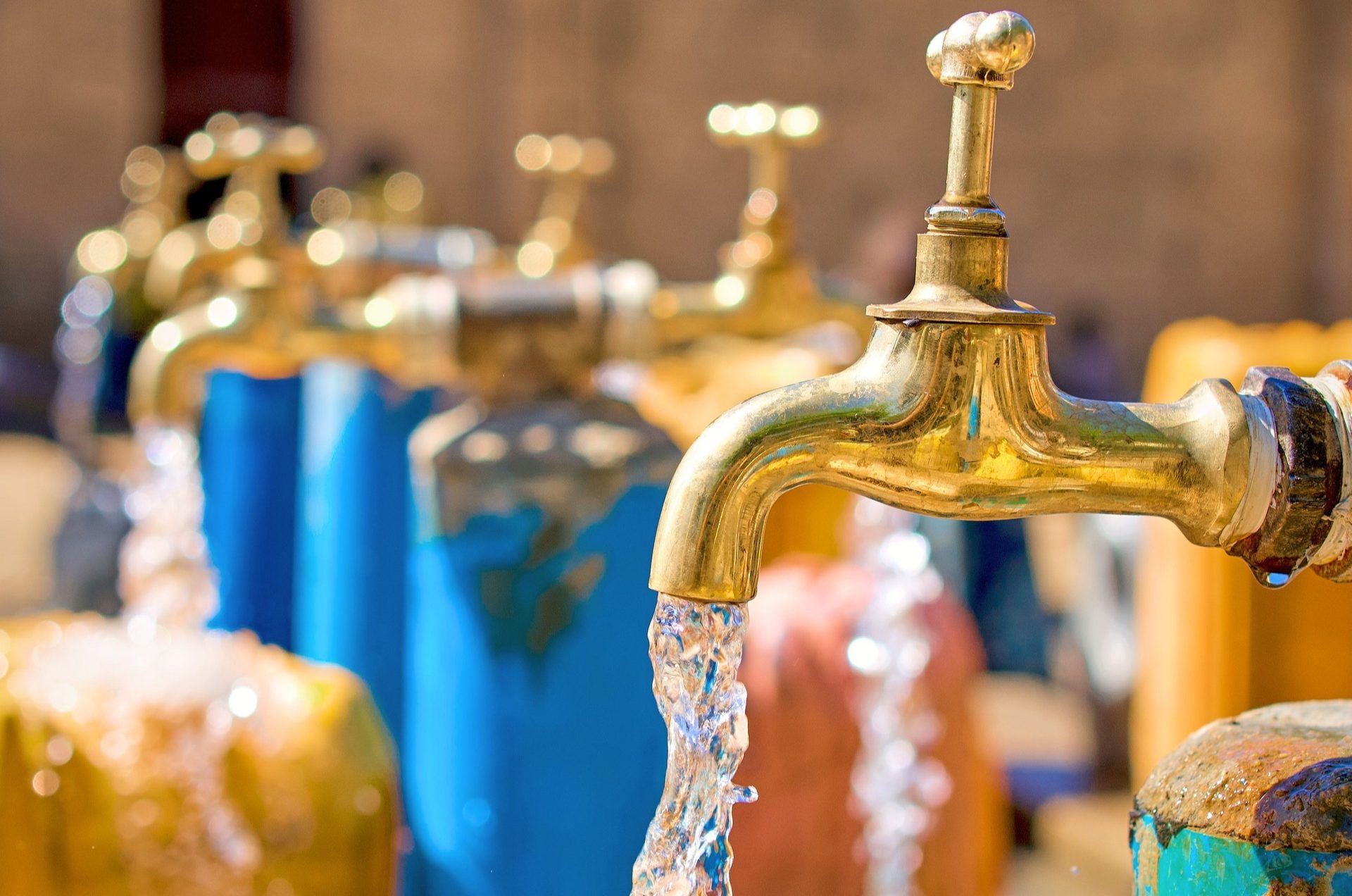 Water flowing from a brass tap at a public water point